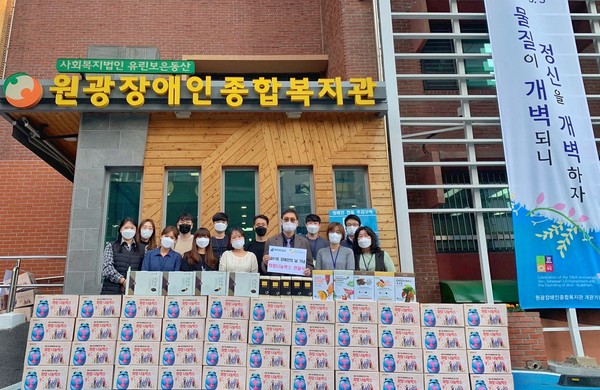 하이트진로는 원광장애인복지관에 희망나눔박스를 전달하고 김선기(앞줄 오른쪽 3번째) 관장을 포함한 직원들이 기념촬영을 진행했다.