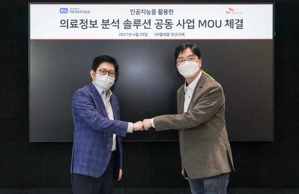가톨릭대 정보융합진흥원장 김대진 교수(좌)와 SKT 김윤 CTO의 모습