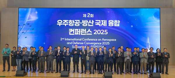 ‘제2회 우주항공·방산 국제 융합 콘퍼런스 2025’ 참석자들이 개회식 후 무대에서 기념촬영을 하고 있다. 사진=경상국립대
